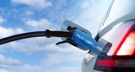 Close up of fuel cell car with connected hydrogen fueling nozzle.