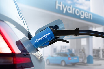 Close up of fuel cell car with connected hydrogen fueling nozzle.