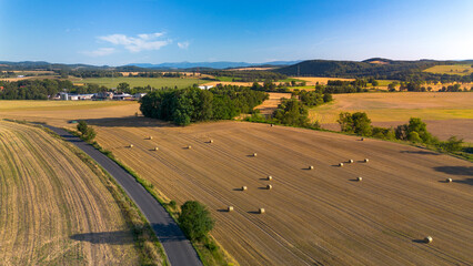 Fototapeta premium Aerial view of round hay bales in a wheat field, Lower Silesia