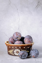 Ripe plums on a light background