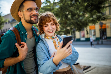 Young couple, on a vacation, exploring the new city and using their phone as gps to help them not get lost.