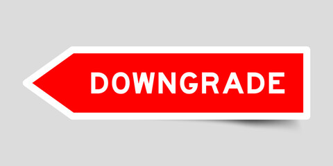 Red color arrow shape sticker label with word downgrade on gray background