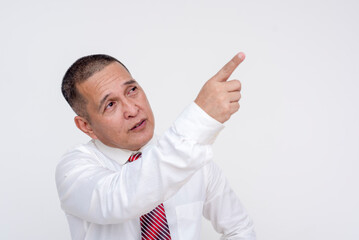 A middle aged manager spotting something to his upper right, pointing at it with his right finger. Isolated on a white background.