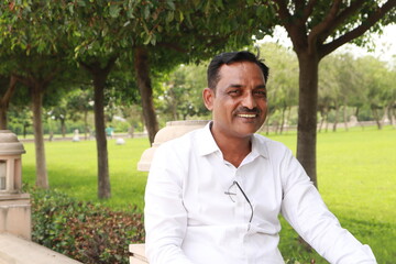 A man wandering in the Janeshwar Mishra park in Lucknow with a green park in backdrop