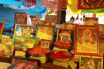 Closeup picture of stalls of tarkulha devi mandir mela with decorative religious photos and chunni
