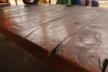 Closeup of an orange plank table with old rustic touch