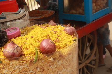 A small street stall of namkeen and bhel puri with small chopped onion 