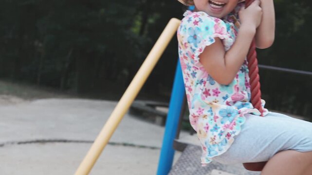 公園のターザンロープで遊ぶ女の子