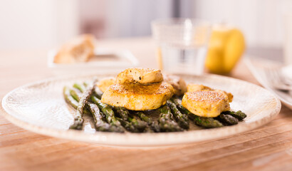 Fried chicken breast pieces with asparagus on white plate