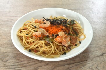 spicy stir fried spaghetti slice squid and shrimp with chili and basil leaf topping shrimp egg in sauce on plate 