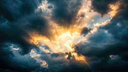 A dramatic sky with rays of sunlight breaking through dark, stormy clouds
