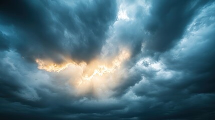 Obraz premium Majestic Sunlight Piercing Through Stormy Clouds - Awe-Inspiring Dramatic Sky Landscape