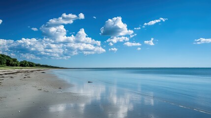 Obraz premium Serene Coastal Landscape with Clear Sky and Clouds - Perfect Summer Day for Relaxation and Reflection