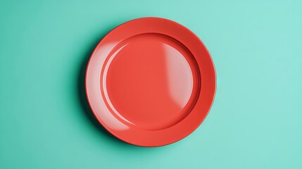 A vibrant red plate against a teal background, perfect for showcasing food or as a decorative piece.
