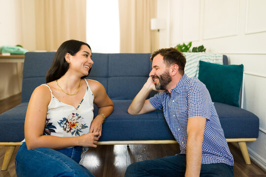 Happy young couple enjoying their time together while relaxing at home and having a cheerful conversation