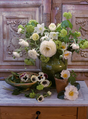 Still life of spring flowers on a marble table with wooden decorative carved background © Erika
