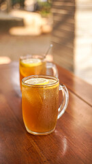 Two glasses of fresh iced lemon tea in twin glasses on a marble base, inside the glass are fresh lemon slices, a perfect drink for hot weather