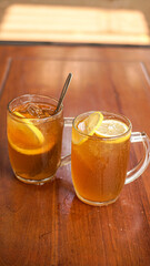 Two glasses of fresh iced lemon tea in twin glasses on a marble base, inside the glass are fresh lemon slices, a perfect drink for hot weather