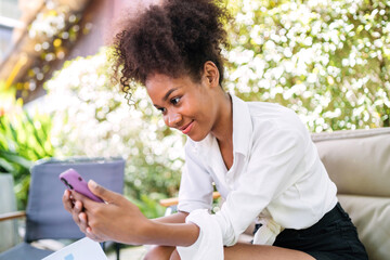 joyful black girl video call selfie using phone. black girl live talking to distance person outdoors or taking selfie. young african american student happy taking picture of herself using smartphone