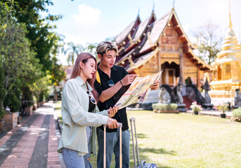Fototapeta premium confused tourist lover lost looking map sheet. young asian couple wondering about location at asia temple become frustrated unfolding paper. asian lover unfolding map finding way to travel after lost