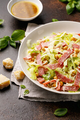 La Scala Salad with romaine lettuce, salami, mozzarella cheese and chickpeas in white plate.