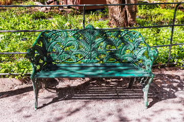 green bench made of cast iron in the park