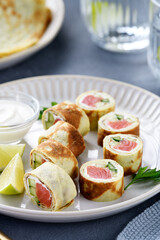 Homemade crepe rolls stuffed with salted salmon, cream cheese and fresh cucumber. Delicious appetizer.
