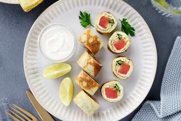 Homemade crepe rolls stuffed with salted salmon, cream cheese and fresh cucumber. Delicious appetizer. top view
