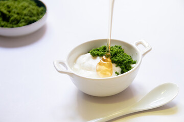 Greek yogurt and wolffia globosa in ceramic bowl isolated on white table background. Wolffia is the nutrient-rich plant-based source of protein and omega3 and vital minerals. Healthy and easy meal.