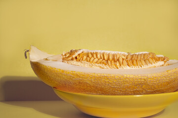 Ripe melon on a yellow background, a copy of the space