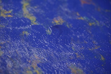Mixed rough paint splatter on a textured blue paint surface, Grungy colorful paint brush strokes backdrop, Abstract multicolor paint splash background