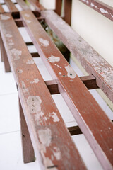 A weathered wooden chair with peeling paint, revealing its rustic charm and aged texture.