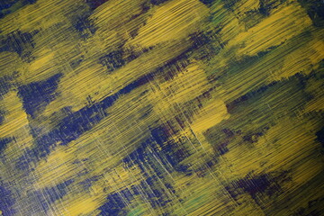 Abstract yellow paint brush splatter on a blue texture surface, Vintage yellow paint stroke pattern...