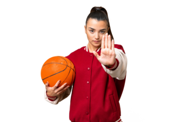 Young Woman playing basketball over isolated chroma key background making stop gesture