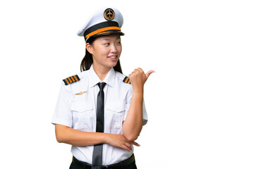 Airplane pilot Asian woman over isolated background pointing to the side to present a product