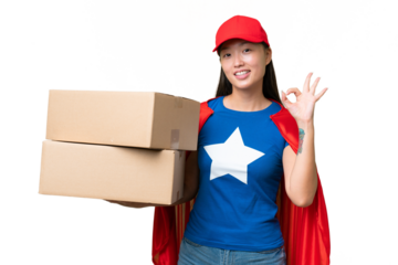 Super Hero delivery Asian woman holding boxes over isolated background showing ok sign with fingers