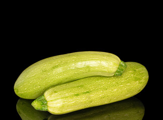 Two ripe zucchini, macro, isolated on black background.