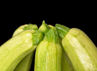 Several ripe zucchini, macro, isolated on black background.