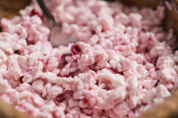 closeup of cottage cheese with sour cream and cowberry jam in wood bowl on table