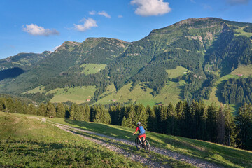 pretty senior woman riding her electric mountain bike and enjoying the spectacular view over the...