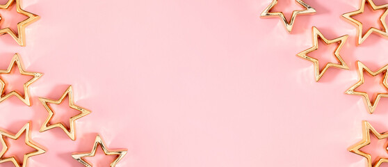 Christmas composition. Golden decorations, stars on pastel pink background. Christmas, New Year, winter concept. Flat lay, top view, copy space