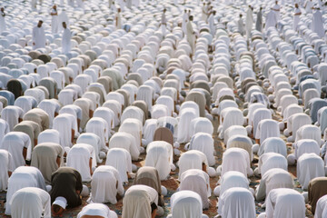Obraz premium Large crowd of people in traditional muslim clothing attending a religious event