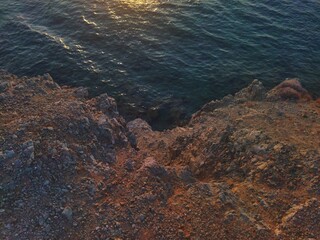 Golden Hour on a Rugged Coastal Cliff Overlooking the Serene Ocean Waters