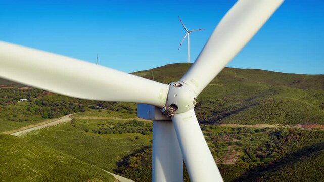Closeup wind turbine produce energy in the green hills, modern power plant, alternative energy sources