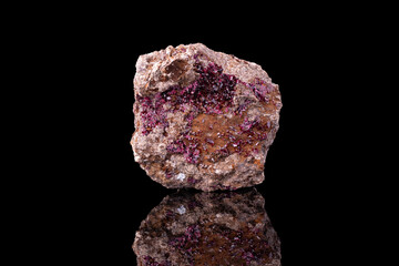 roselite on matrice. Specimen from Bou Azzer Mine, Morocco. photography isolated on black background. macro detail close-up mineral crystal unpolished semi-precious gemstone.
