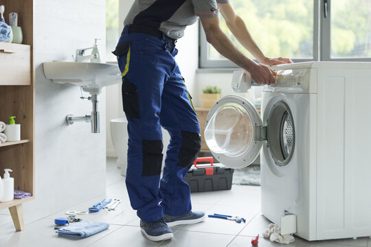Repairman fixing a washer at home