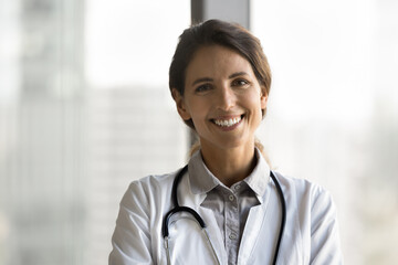 Head shot portrait beautiful Latina doctor wear white uniform, posing, looking at camera, feel...