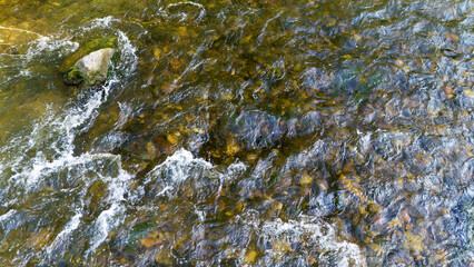 Zdjęcie płynącej wody i kamieni pod wodą w strumieniu, zasoby graficzne, tekstura, widok z góry. © Stanisław Błachowicz