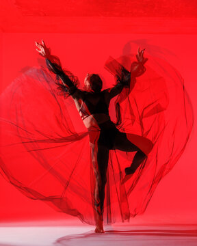 Graceful Dancer in Red Hue - An artistic portrayal of a dancer&rsquo;s silhouette, showcasing the beauty of dance through soft, flowing lines and a bold, red backdrop.