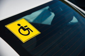 Close-up sticker on the car window warning that the driver is disabled